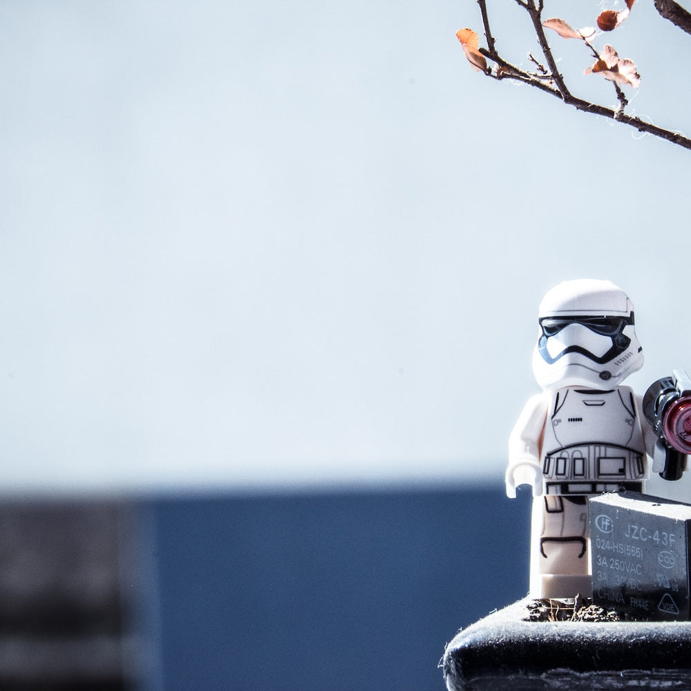 Lego storm trooper and a discarded battery in nature