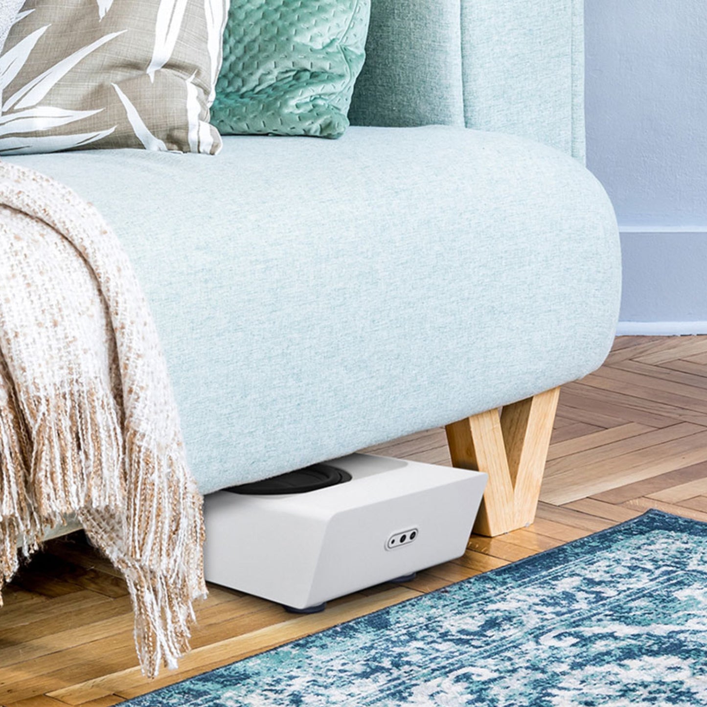 White Bluesound Pulse Sub+ under couch