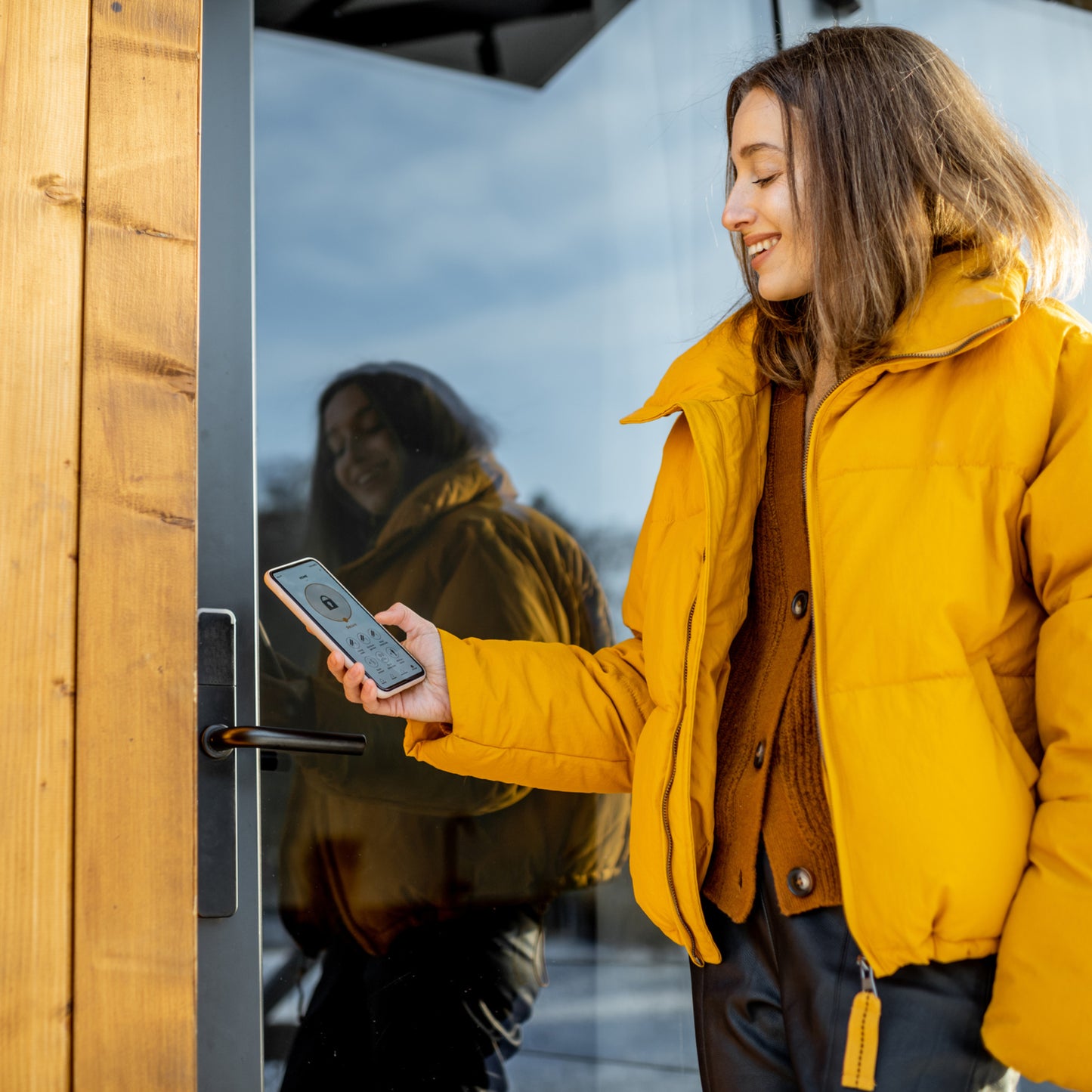 woman using a smart phone to unlock a door