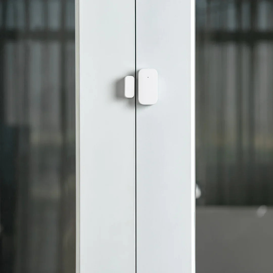 a close up of a white cabinet with two doors with a sensor